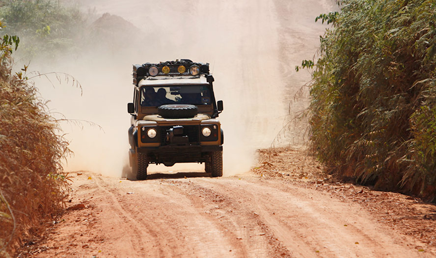 4x4 traveling along long dusty road