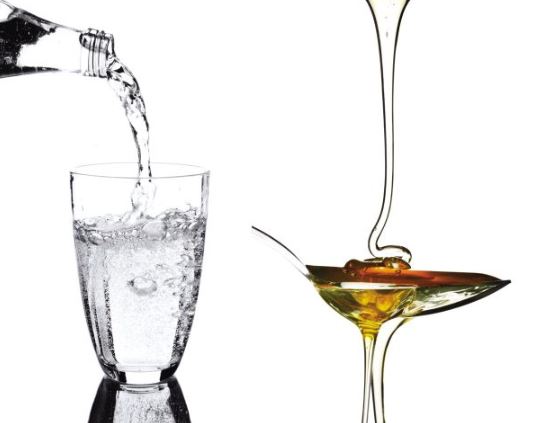 Pouring two different oils into two glasses to check the viscosity difference